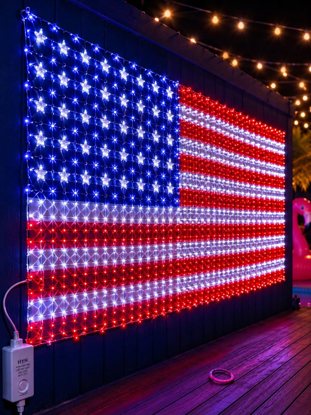 HYH American Flag LED net light review showing 420 super-bright red white and blue LEDs fully illuminated on a backyard fence wall for 250th Anniversary patriotic display by Vivid Vicky