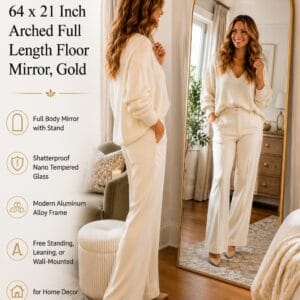 DUMOS 64 x 21 inch gold arched full length floor mirror with aluminum frame leaning against a bedroom wall