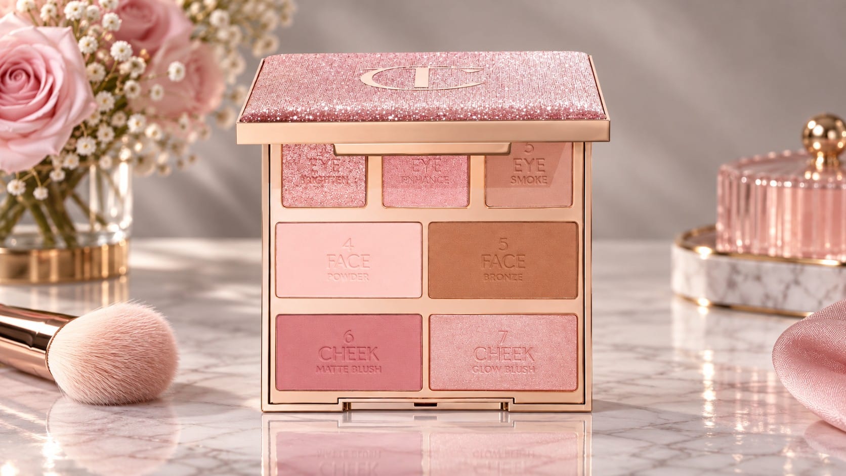 Charlotte Tilbury Instant Look in a Palette open on a marble vanity, showing seven numbered pans for eyes, face and cheeks under a glittering pink lid with the CT logo, beside pink roses and a makeup brush.